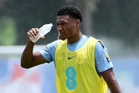 Ollie Watkins splashes his face with water during training