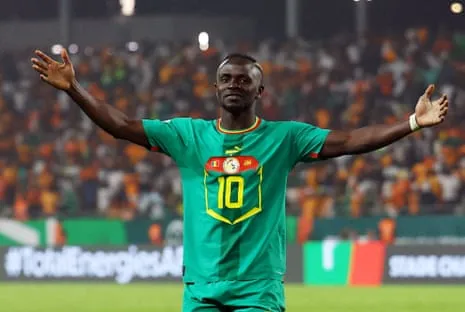 Célébration de Sadio Mané Sadio Mané, l'attaquant sénégalais portant le numéro 10, célèbre un but pour son pays à la Coupe d'Afrique des Nations en se tenant devant les supporters, les bras écartés.