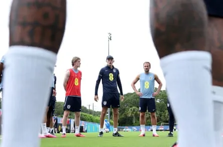 Thomas Tuchel giving instructions, photographed between the legs of one of the players