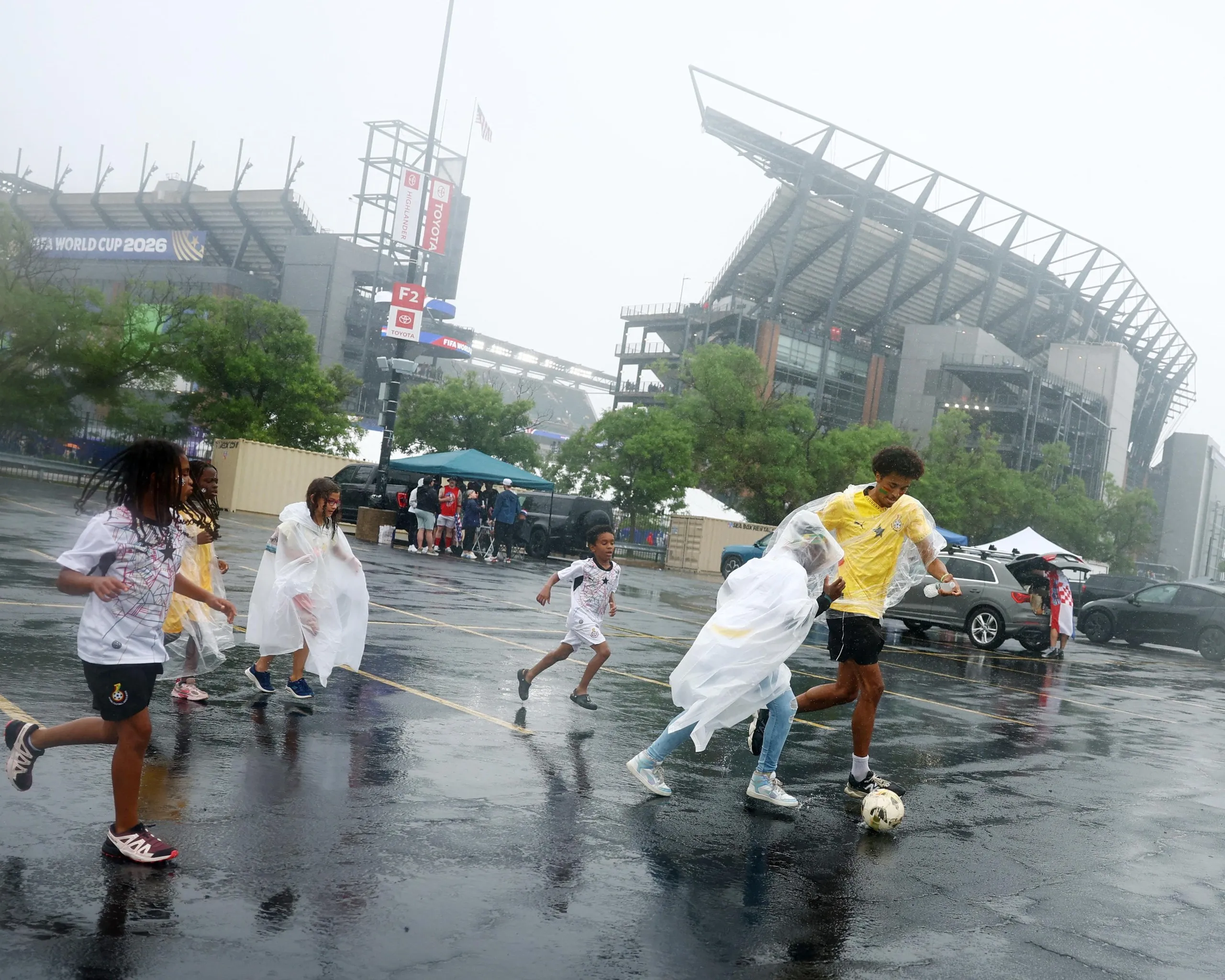 People play in the rain outside the stadium.