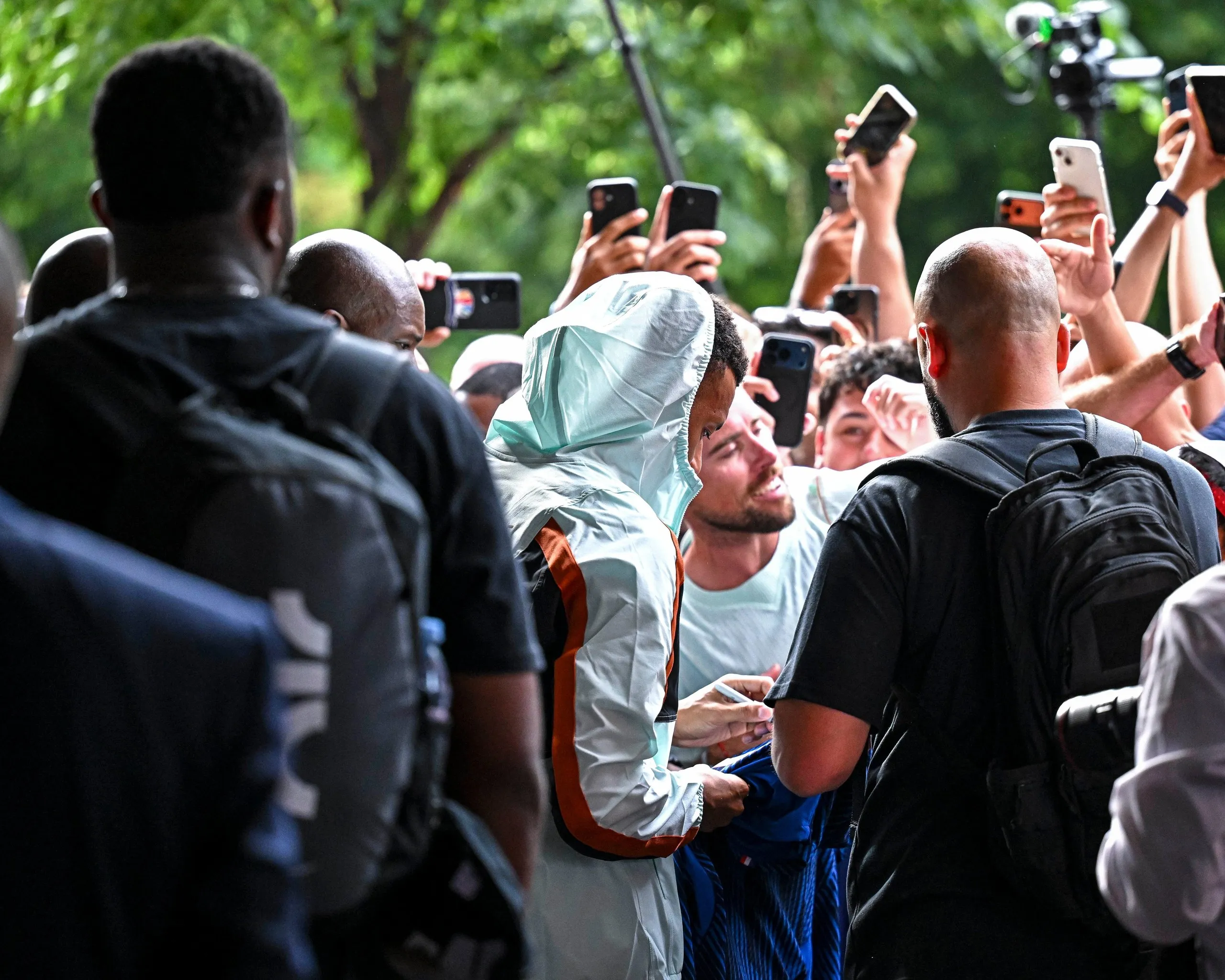 Kylian Mbappé, the captain of France’s men’s football team, signs autographs and poses for selfies with fans outside the team’s World Cup 2026 hotel in Boston, Massachusetts.