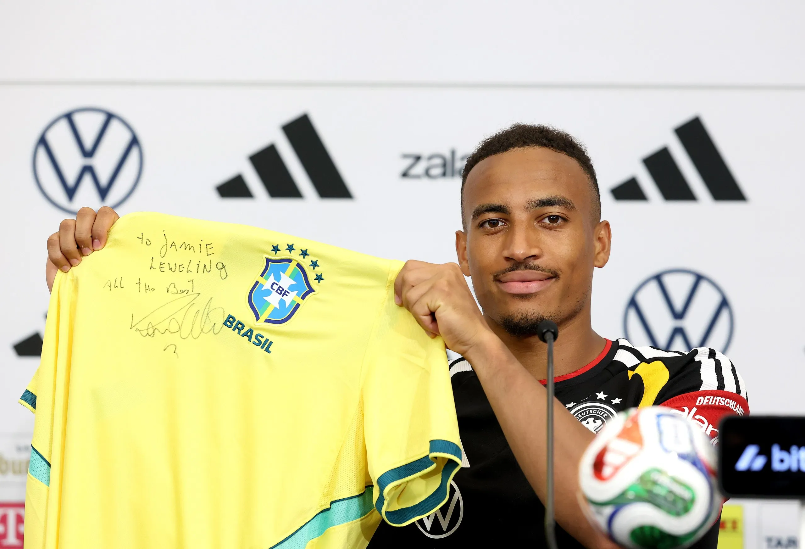 Jamie Leweling holding a Brazil shirt with a personal dedication from Ronaldo