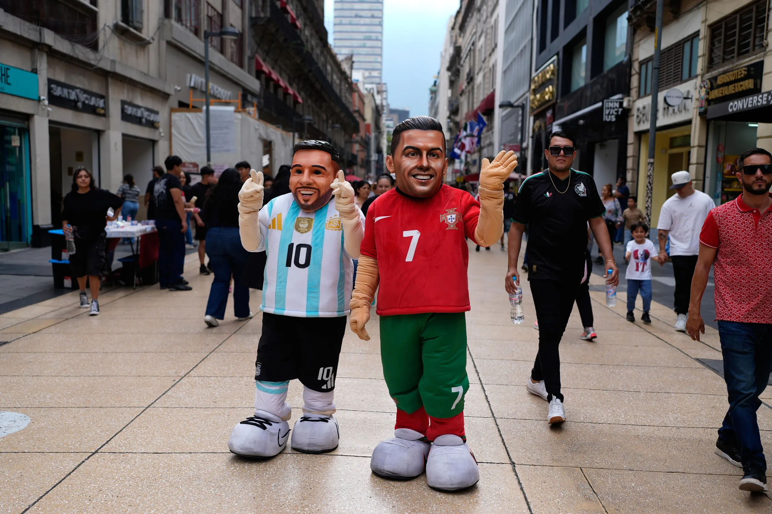 Mascots portraying Lionel Messi and Cristiano Ronaldo greet passersby in Mexico City