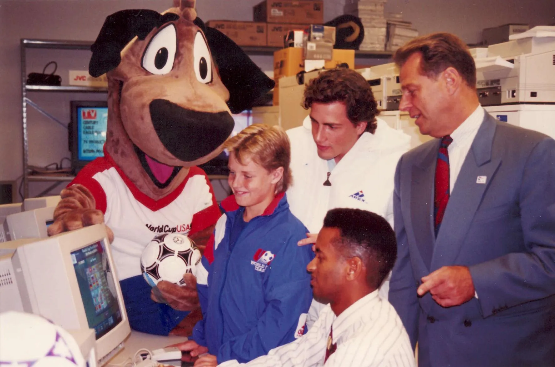 Striker, child star Zachary Ty Bryan, Carlos Parada and Alan Rothenberg work at a computer.