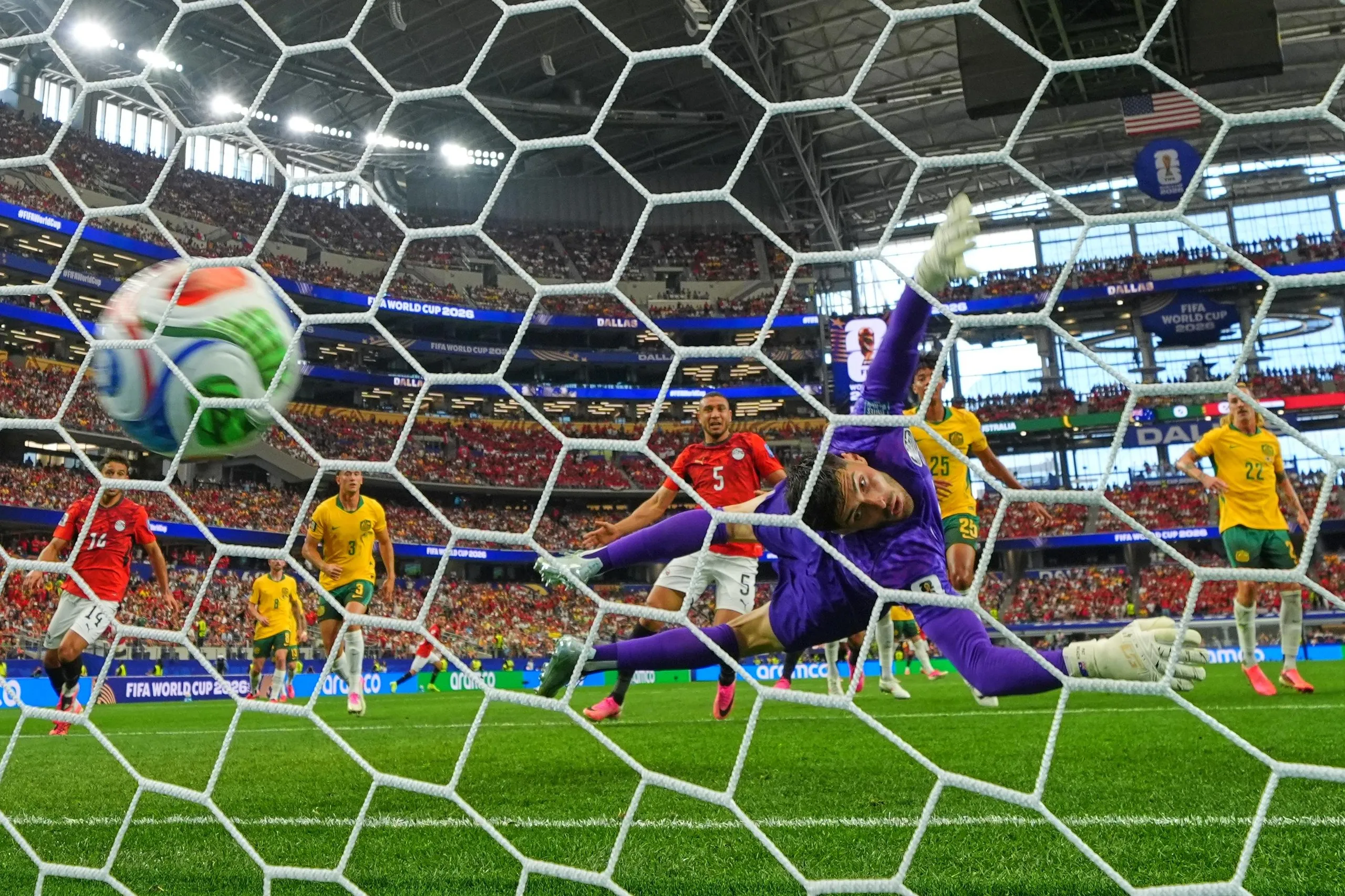 Egypt’s Emam Ashour (8) scores the opening goal past Australia goalkeeper Patrick Beach