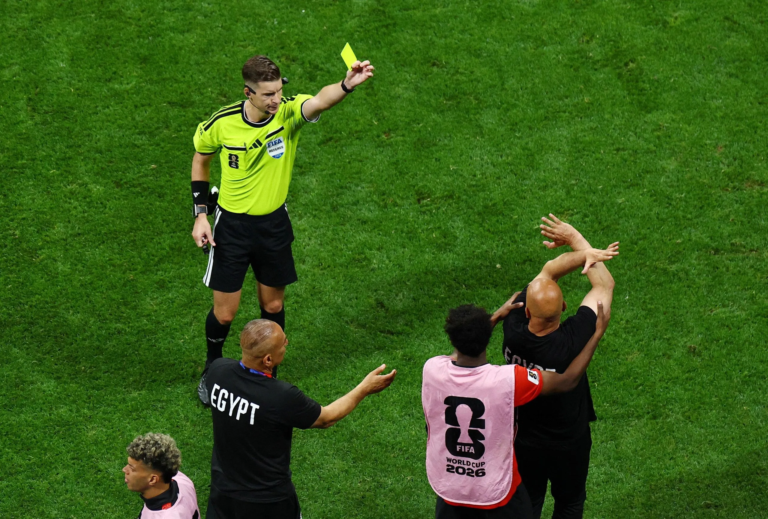 The Egypt coach, Hossam Hassan, is shown a yellow card by the referee, François Letexier, during the game against Argentina