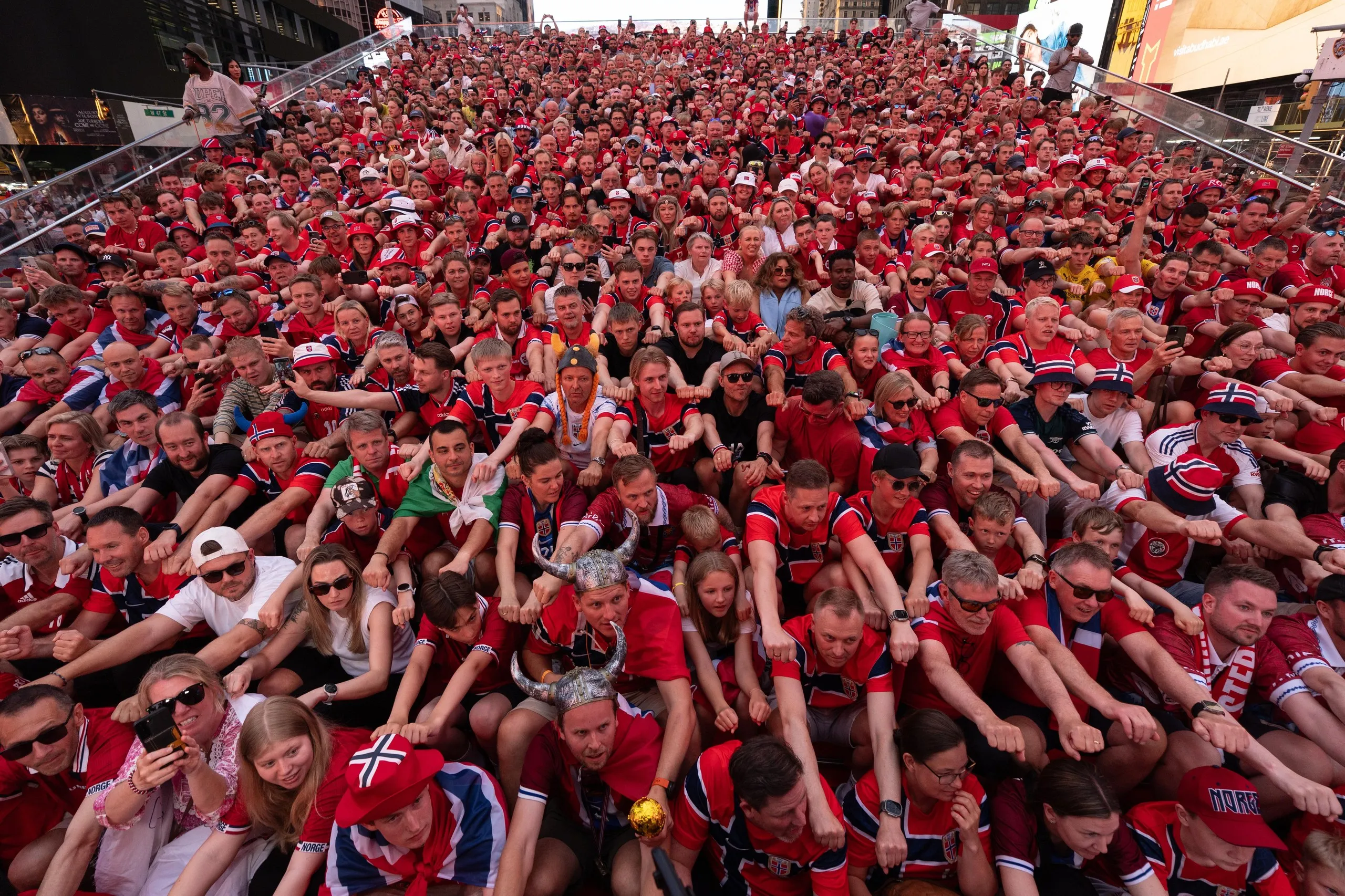Norway supporters gather to perform their rowing celebration on the iconic red steps in Times Square.