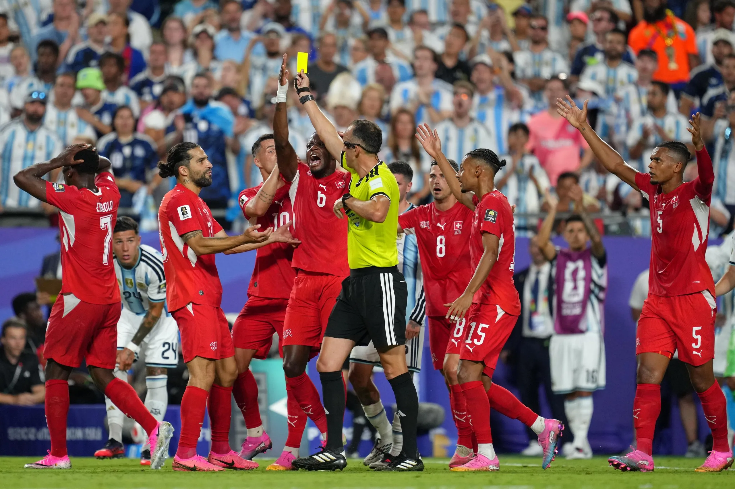 Switzerland players plead their case with referee Joao Pinheiro after attacker Breel Embolo was shown a second yellow card against Argentina